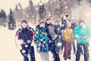 group of young people throwing snow in the air photo