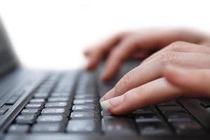 Isolated female hand typing on laptop keyboard photo