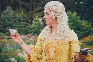 Portrait of blonde woman dressed in historical Baroque clothes with old fashion hairstyle, outdoors. photo