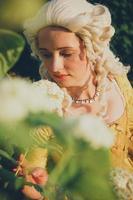 Portrait of blonde woman dressed in historical Baroque clothes with old fashion hairstyle, outdoors. photo