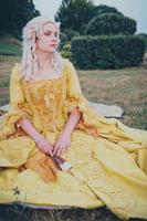 Portrait of blonde woman dressed in historical Baroque clothes with old fashion hairstyle, outdoors. photo