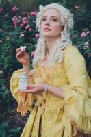 Portrait of blonde woman dressed in historical Baroque clothes with old fashion hairstyle, outdoors. photo