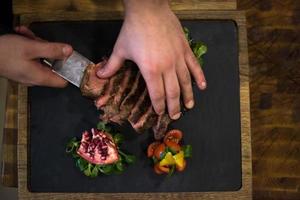 top view of Chef hands serving beef steak photo
