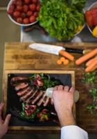 top view of Chef finishing steak meat plate photo