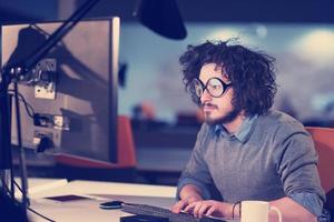 man working on computer in dark startup office photo