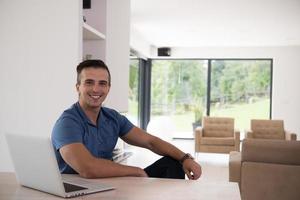 Young man with laptop at home photo