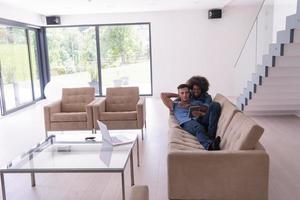 young multiethnic couple relaxes in the living room photo