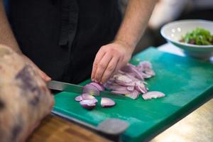 Chef  hands cutting the onion with knife photo