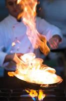 Chef doing flambe on food photo