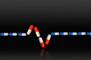 signo de electrocardiograma con pastillas azules y rojas foto