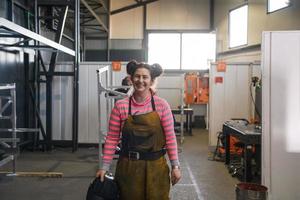 a portrait of a women welder holding a helmet and preparing for a working day in the metal industry photo