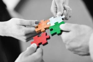 Group of business people assembling jigsaw puzzle photo