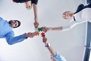 Group of business people assembling jigsaw puzzle photo