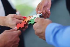 Group of business people assembling jigsaw puzzle photo