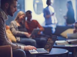 businessman using laptop, concentrated employee analyzing project results, watching webinar or distance staff training photo