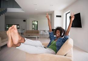 African american woman at home in chair with tablet and head phones photo