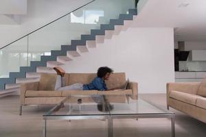 African American woman using laptop on sofa photo