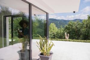 mujer afroamericana tomando café mirando por la ventana foto