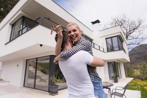 couple hugging in front of  new luxury home photo