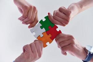 Group of business people assembling jigsaw puzzle photo