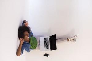 african american woman sitting on floor with laptop top view photo