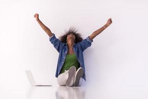 mujer afroamericana sentada en el suelo con una laptop foto