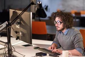 man working on computer in dark startup office photo