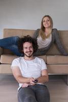 Young couple on the sofa watching television photo