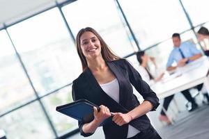 business woman with her staff in background at office photo