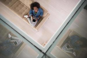 african american woman at home with digital tablet top view photo