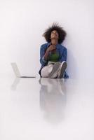 african american woman sitting on floor with laptop photo