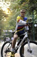 Fit happy young man smiling on bike photo