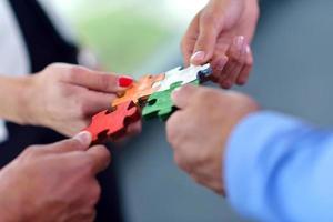 Group of business people assembling jigsaw puzzle photo