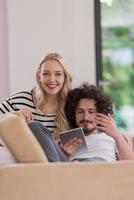 couple relaxing at  home with tablet computers photo