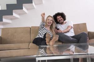 Young couple on the sofa watching television photo