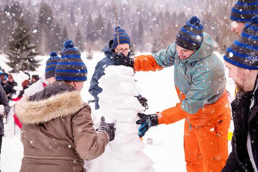 grupo de jóvenes haciendo un muñeco de nieve foto