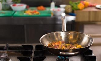 chef flipping vegetables in wok photo