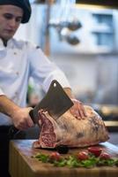 chef cutting big piece of beef photo