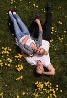 man and woman lying on the grass photo