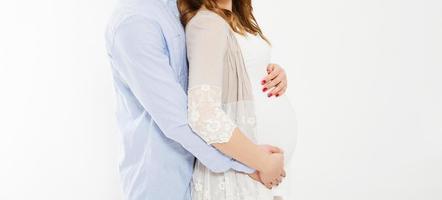 cropped photo of cheerful young man standing with his pregnant woman isolated over white background wall