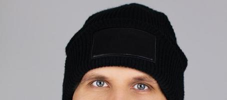 sombrero negro en blanco sobre la cabeza del hombre aislado sobre fondo gris foto