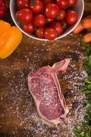 top view of raw steak on wooden table photo