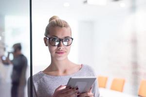 woman working on digital tablet in night office photo