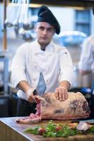 chef cutting big piece of beef photo