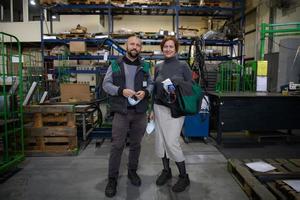 trabajadores industriales con máscaras faciales protegidas contra el virus de la corona discutiendo sobre la producción en fábrica. personas que trabajan durante la pandemia de covid-19. foto