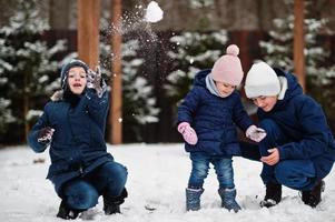 Three kids playing in winter day. Brothers with yongest sister. photo