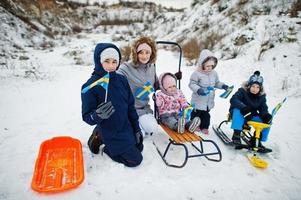 familia escandinava con bandera de suecia en el paisaje sueco de invierno. foto