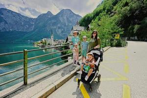 madre con cuatro hijos contra el hermoso paisaje escénico sobre el lago de los alpes austriacos en hallstatt, austria. foto