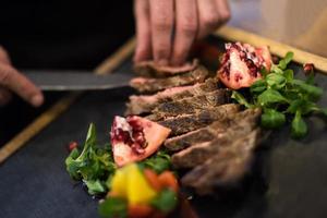 closeup of Chef hands serving beef steak photo