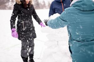 group of young people making a snowman photo